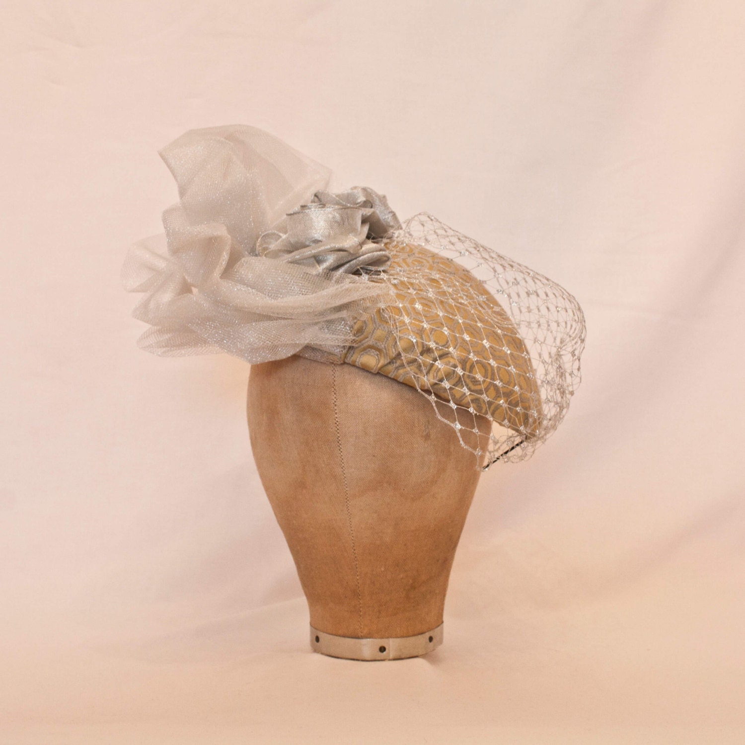 Beautiful handmade ladies occasion hat in pale gold and silver, decorated with handmade ribbon roses, veiling and tulle