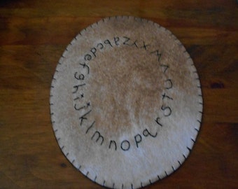 Alphabet candle mat measuring 8 inches across