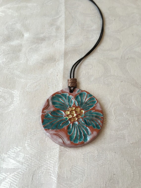 Terracotta pendant w teal floral design. by JewelryDesignsbyJoyD