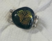 Fused glass ring: fused dichroic swirls and a black background; silver plated stretch ring; dichroic glass