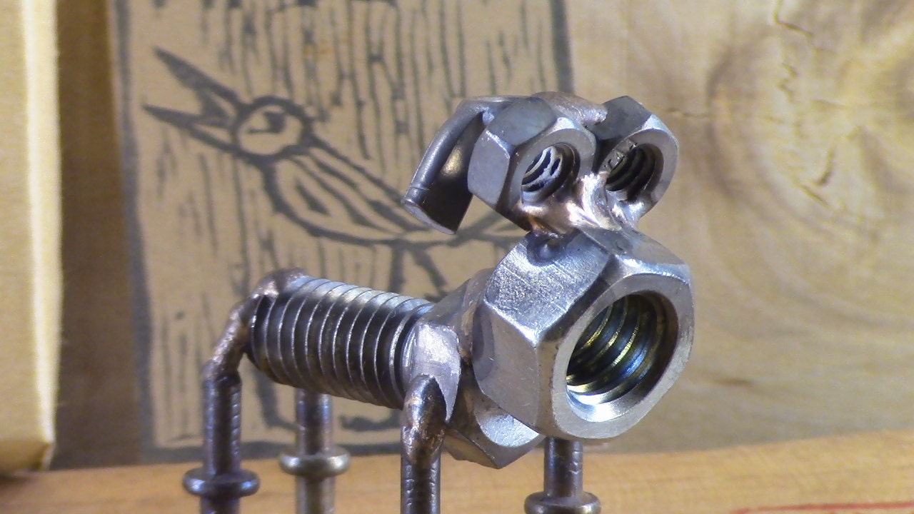 welded nut and bolt dog sculpture with ink by CageFreeMetalWorks