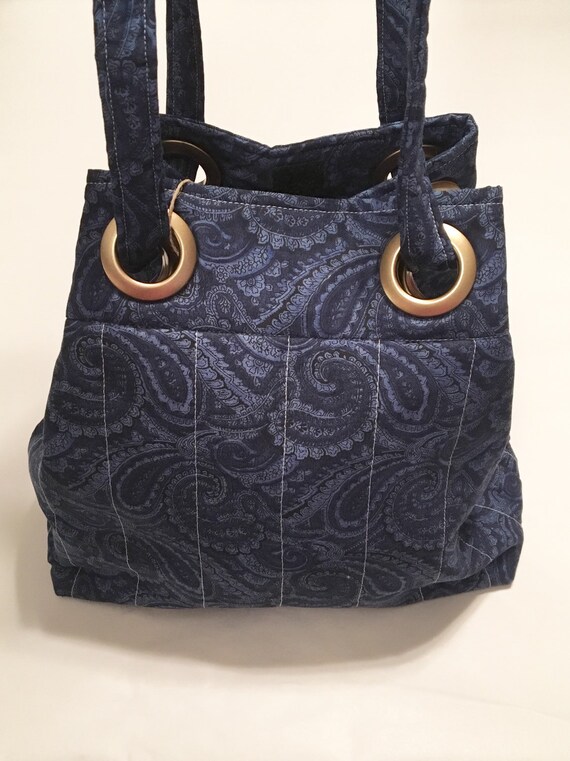 Blue fabric purse with grommets.