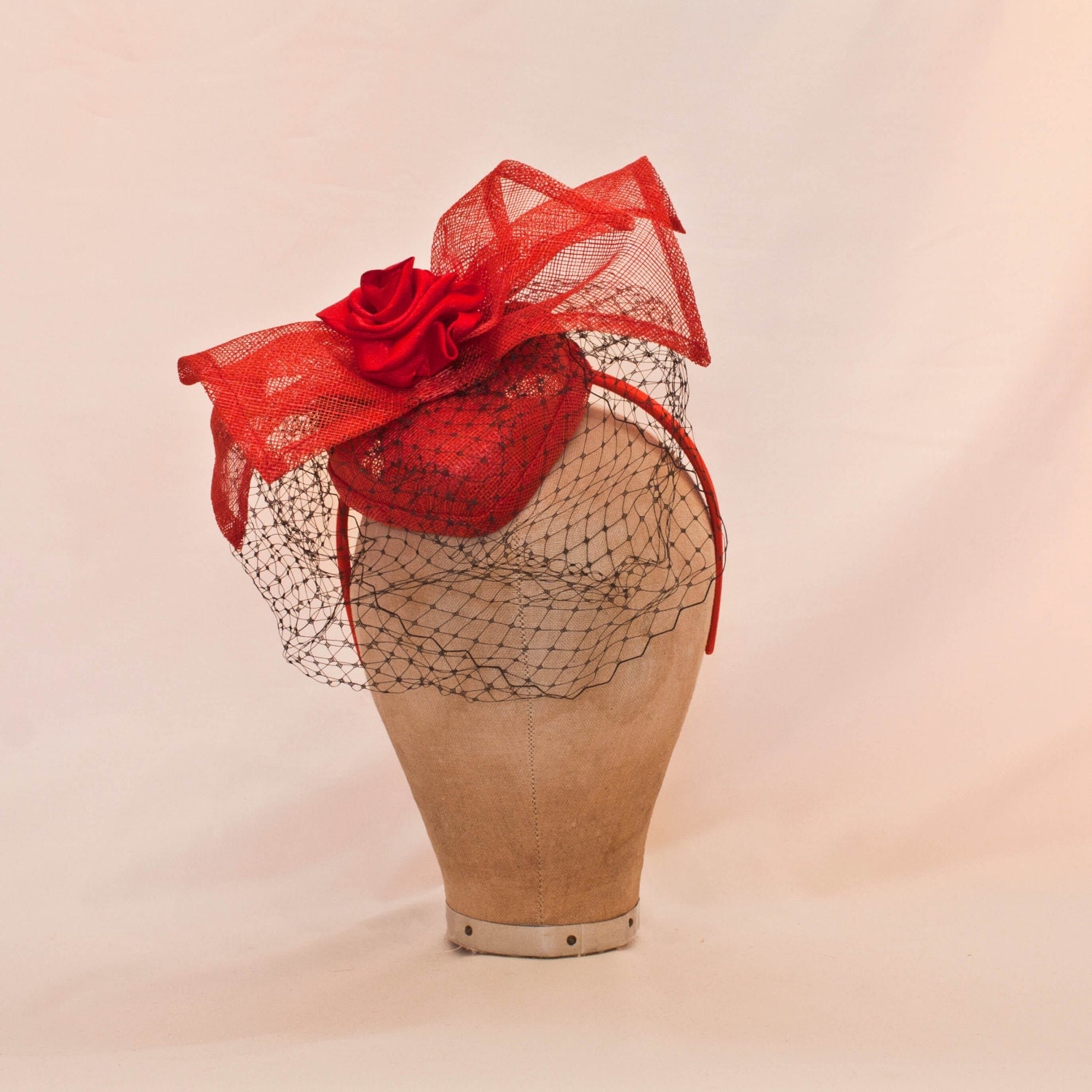 Handmade red heart shaped ladies fascinator/hat decorated with bow and ribbon rose and black veil
