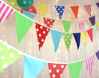 Vibrant multi coloured party bunting with spots, stripes, plains, red, yellow, green, blue, pink, orange, purple. The perfect party bunting