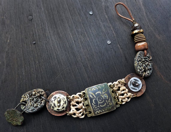 Tectonic. Tribal assemblage bracelet with antique buttons and artisan beads. Primitive mixed media jewelry.