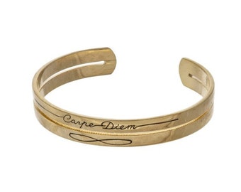 Gold tone cuff bracelet stamped with "Carpe Diem."