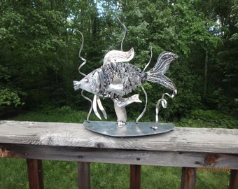 This is an aluminum fish swimming in seaweed.