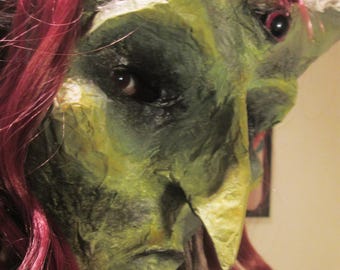 Mask from paper mache. Witch redhead green with third eye.