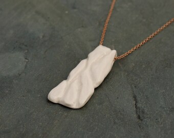 Small hand carved porcelain pendant