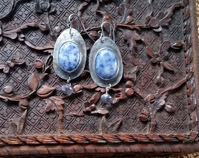 Earrings with Blue Denim Cabochons Set in Sterling Silver and Hand Stamped. The dangle is a pale Blue Iolite
