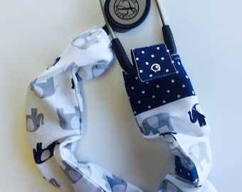 Stethoscope cover featuring a white material with grey elephants and polka dots
