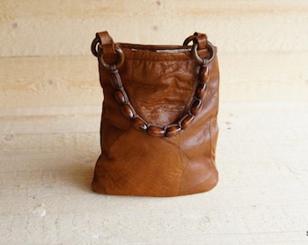 Bag made of recycled leather with straps of wooden beads