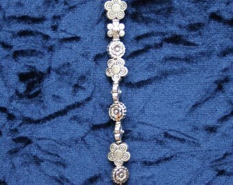 Silver sun catcher of dragonfly and flowers.