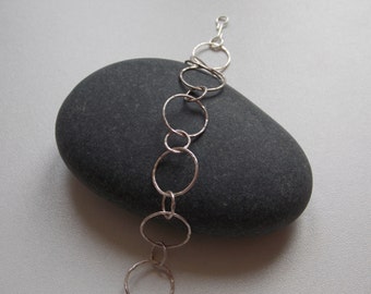 Modern and fine silver bracelet with interlaced hammered rings