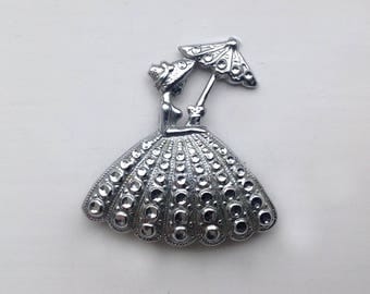 An evocative and charming 1940s/50s white chrome/metal Brooch/Pin of a girl with a parasol
