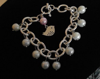 silver bird with white and pink pearl bracelet