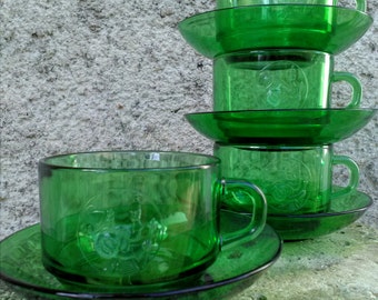 Four French 'La bonne arquebuse' 'vereco' green glass cups and saucers