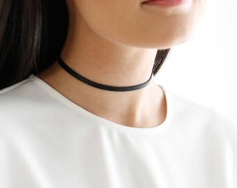 Collier de style choker, fait d'une bande de cuir.