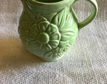 Raised floral pattern green jug