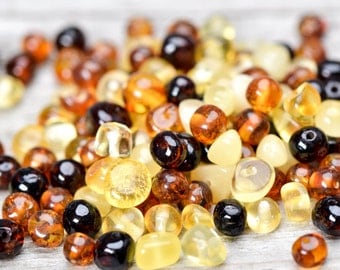 50 pcs Polished colored Baltic amber beads with drilled hole.