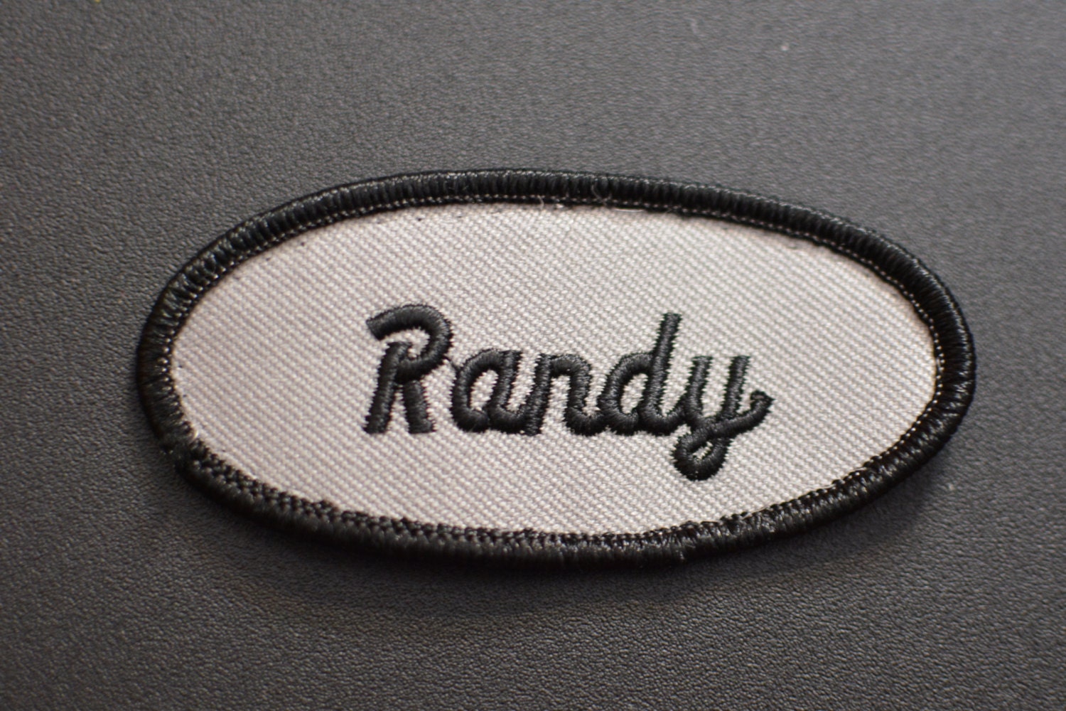 black-iron-on-name-patch-on-gray-background-vintage-embroidered