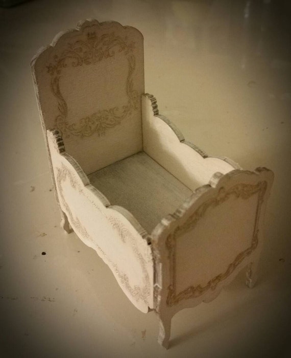 Miniature dollhouse crib with delicate detailing and finished
