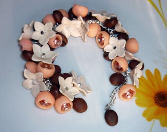 Bracelet on the hand of female coffee flowers, a coffee grain bracelet, an exclusive bracelet with flowers. Bracelet as a gift to a girl.