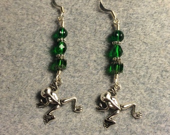 Small silver jumping frog charm dangle earrings adorned with emerald green Czech glass beads.