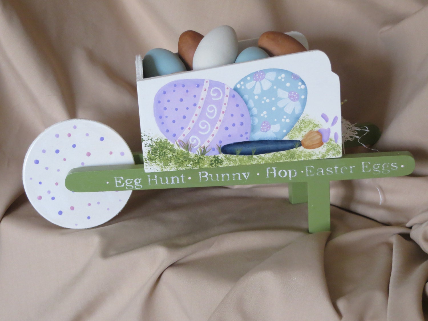 Wood wheelbarrow with painted Easter Eggs on the sides and