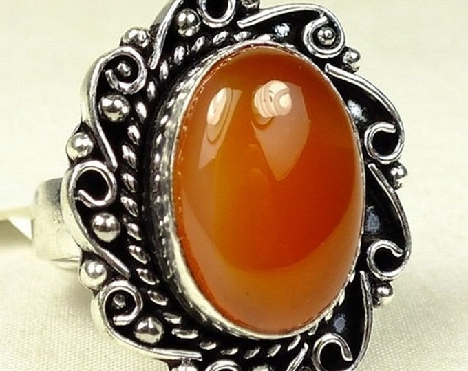 Storewide 25% Off SALE ladies cocktail ring features center 'Red Onyx' polished stone set in scrolling white metal setting.