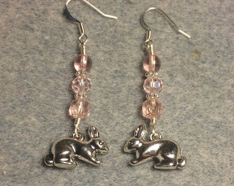 Silver rabbit charm dangle earrings adorned with pink Czech glass beads.