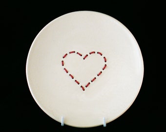 Handmade white ceramic plate with red embroidered heart