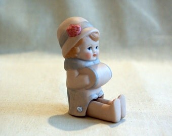Cute miniature porcelain doll with winter muff and cloche hat