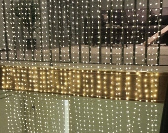 1800 Fairy Lights: Curtain lights with 36 silver strands of light, each with 50 warm white LEDs. Backdrop for weddings, dances, and events.