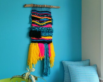 Woven wall hanging with a retro eighties Memphis vibe. Fibre art. Modern weaving. Interior decor. Hot pink, yellow, black.