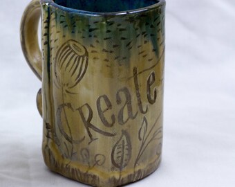 Hand-built mug with a creamy white glaze and carved words or trees