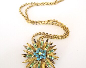 Gold tone metal Starburst brooch and pendant with green rhinestones and blue beads