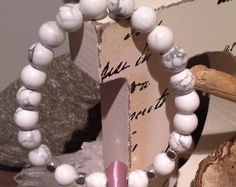 96) Bracelet en pierres semi précieuse de Howlite ornée de billes argentées dont la centrale en verre rose