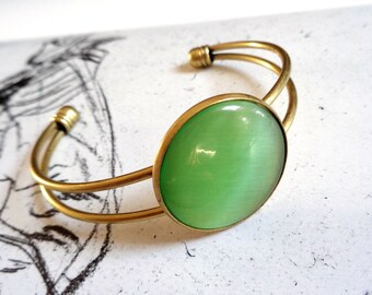Bronze tone bangle bracelet cateye glass cabochon light green