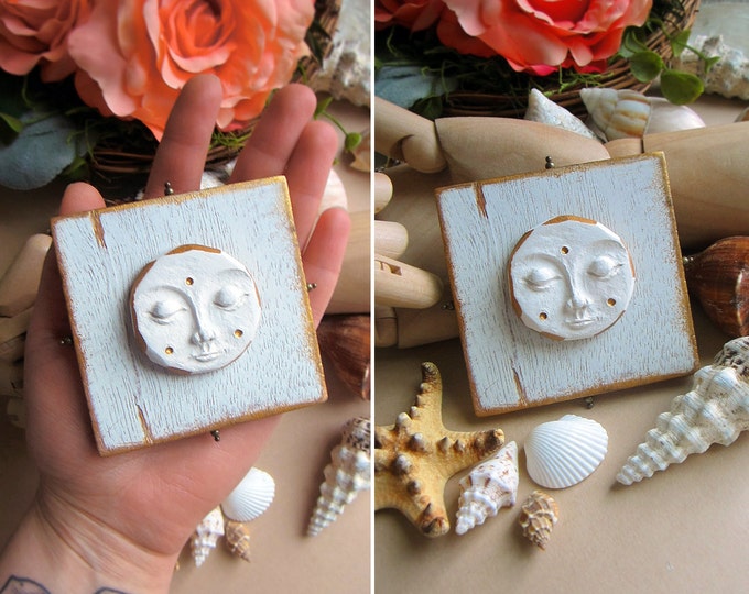 Moon Goddess wall hanging. Hand sculpted clay moon on a wooden blank. Decorated with white & gold paint. Size 3" x 3". Comes with a hanger.