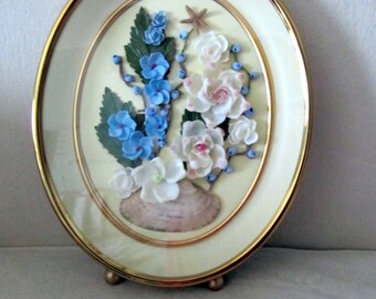 Gold shadow box frame with shell flowers