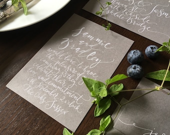 Handwritten calligraphy invitation on grey card