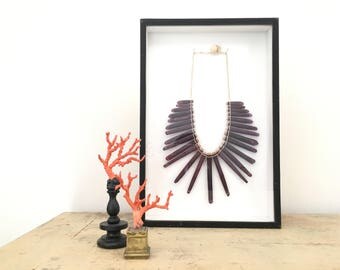 Old necklace spines of sea urchins pencil under glass.