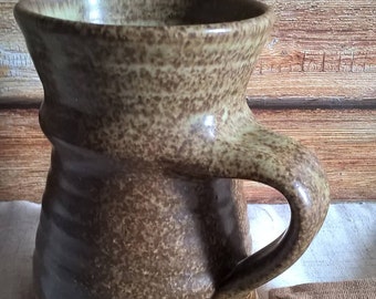 Hand thrown mug. Lovely shape. Brown mottled glaze shading from light to darker. Handle beautifully formed. Quite large.