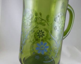 Green retro pitcher with floral pattern painted on side.