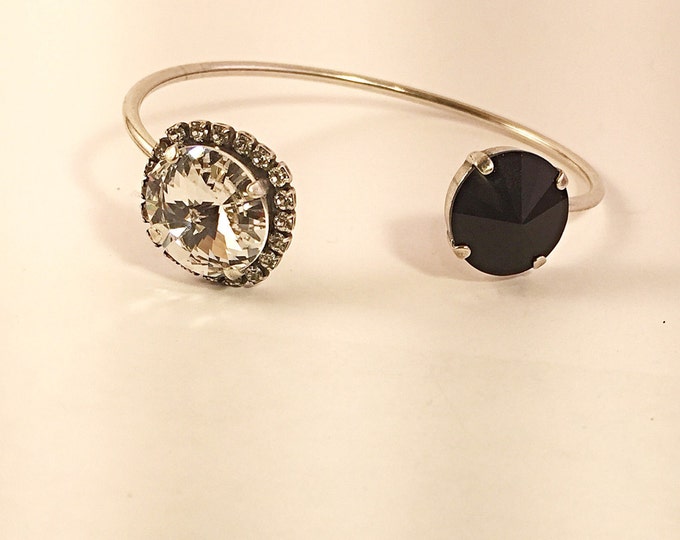 Feel glamorous and confident in this jet black and crystal rivoli bangle open cuff bracelet, perfect for stacking and layering.
