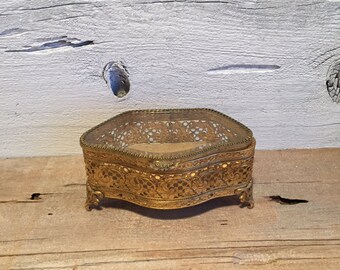 Gold filigree jewelry box with beveled glass lid.