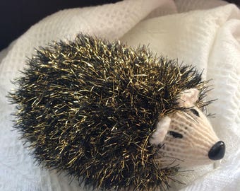Hand knitted hedgehog soft toy plushie.