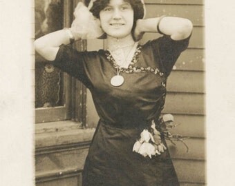 vintage photo 1913 Pretty woman Tulip flowers hang From Dress Arms Up Hair Bow RPPC