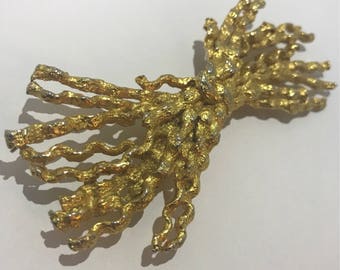 Huge broche noeud en metal doré torsadé. Signé d'une maison française des années 1970